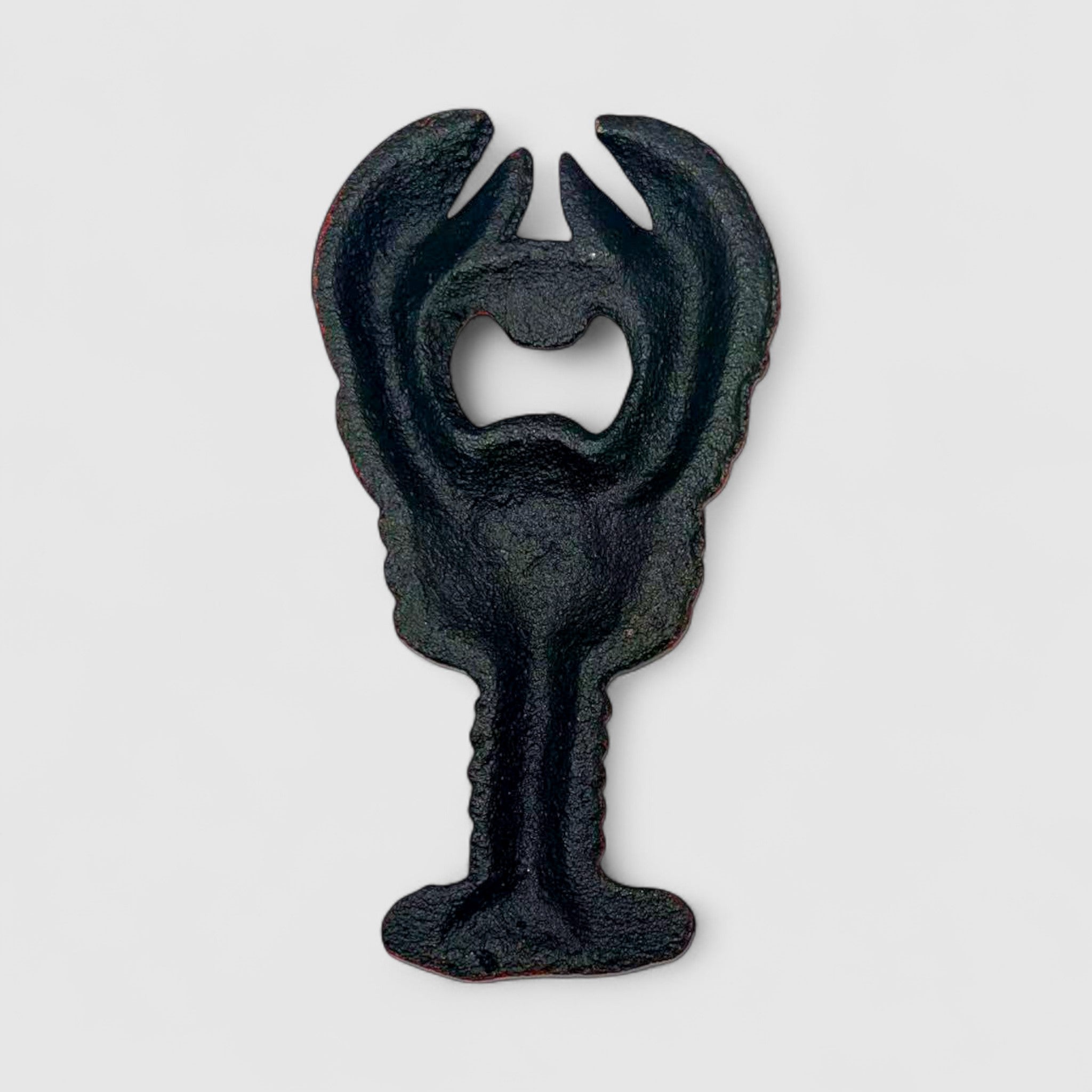 Rustic cast iron bottle opener shaped like lobster with worn vintage finish detail