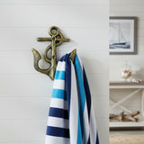 Antique brass cast iron marine anchor hook with rope holder on white wall