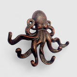 Copper cast iron octopus hook with detailed suction cup details on tentacles, studio shot