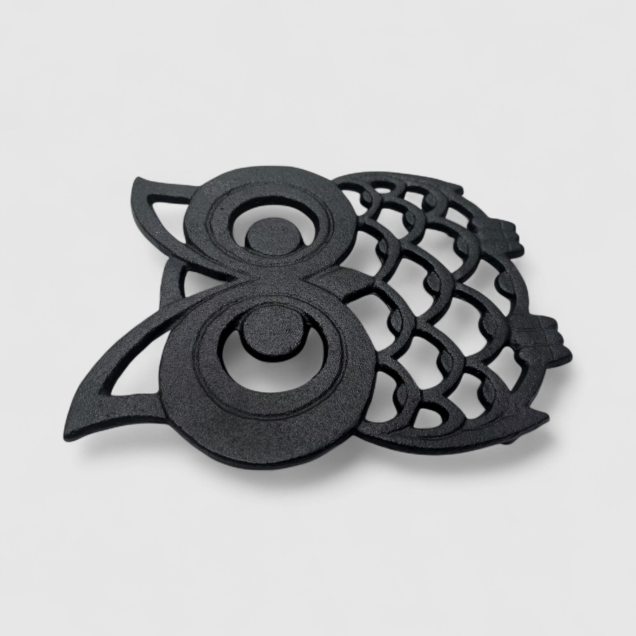 Cast iron owl trivet side view, dark finish with openwork wing and body details