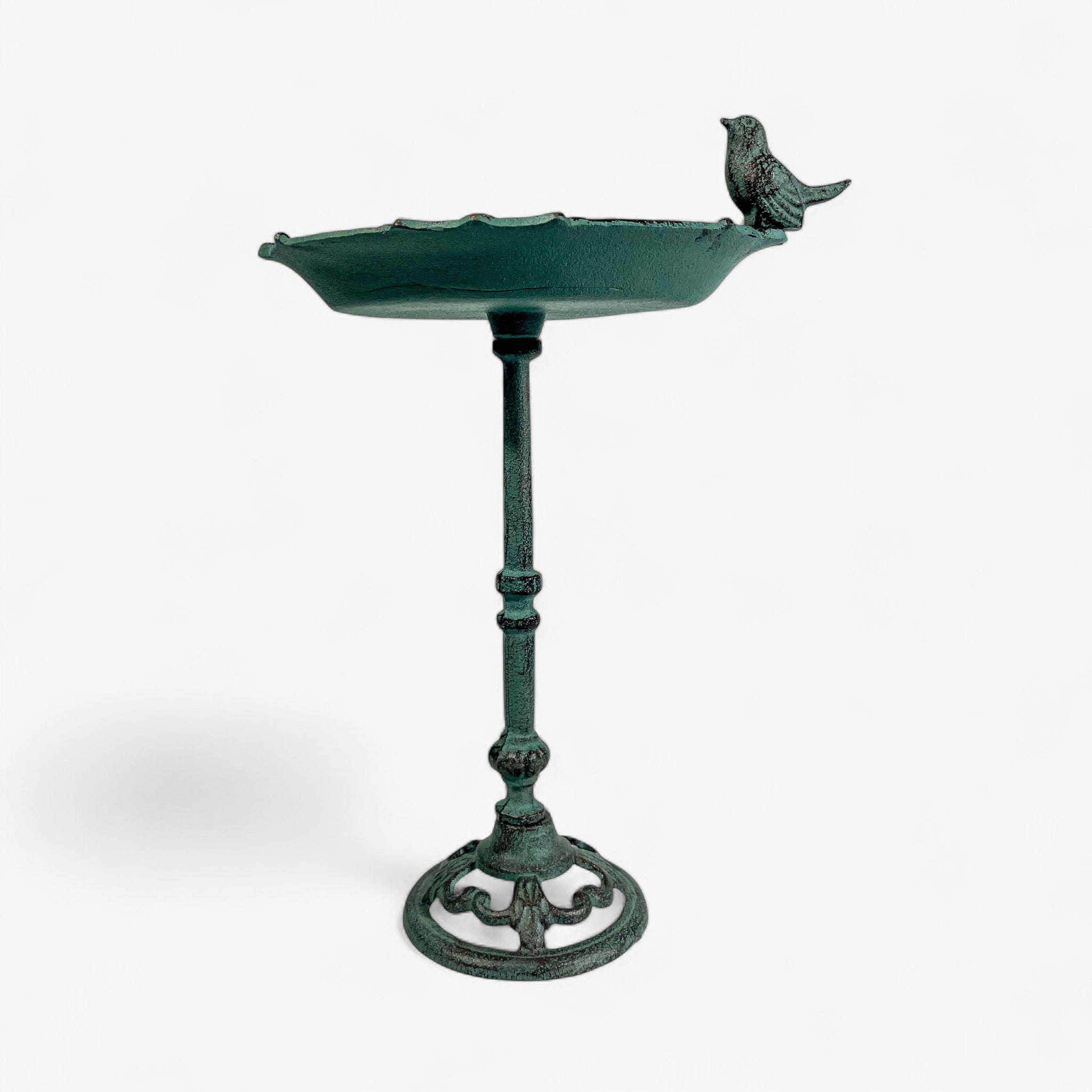 Side profile of green patina cast iron bird bath with perched bird and turned pedestal stem detail