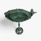 Cast iron bird bath angled view displaying full pedestal, ornamental base, verdigris patina, and bird