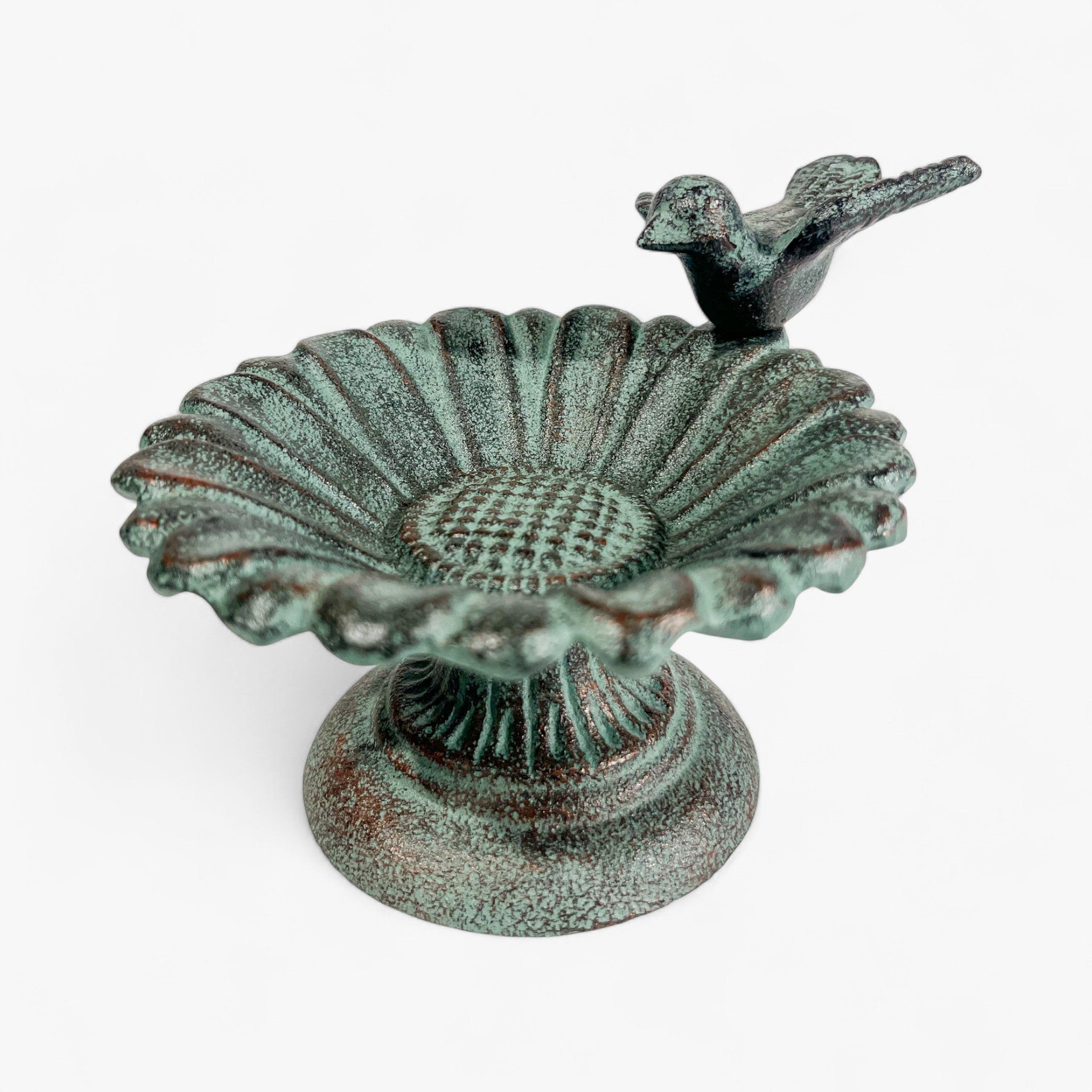 Verdigris cast iron bird bath with fluted sunflower bowl and bird figurine, studio shot