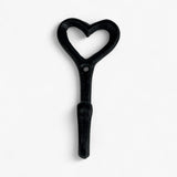 Black cast iron decorative heart hook with rounded handle, detailed weathered texture