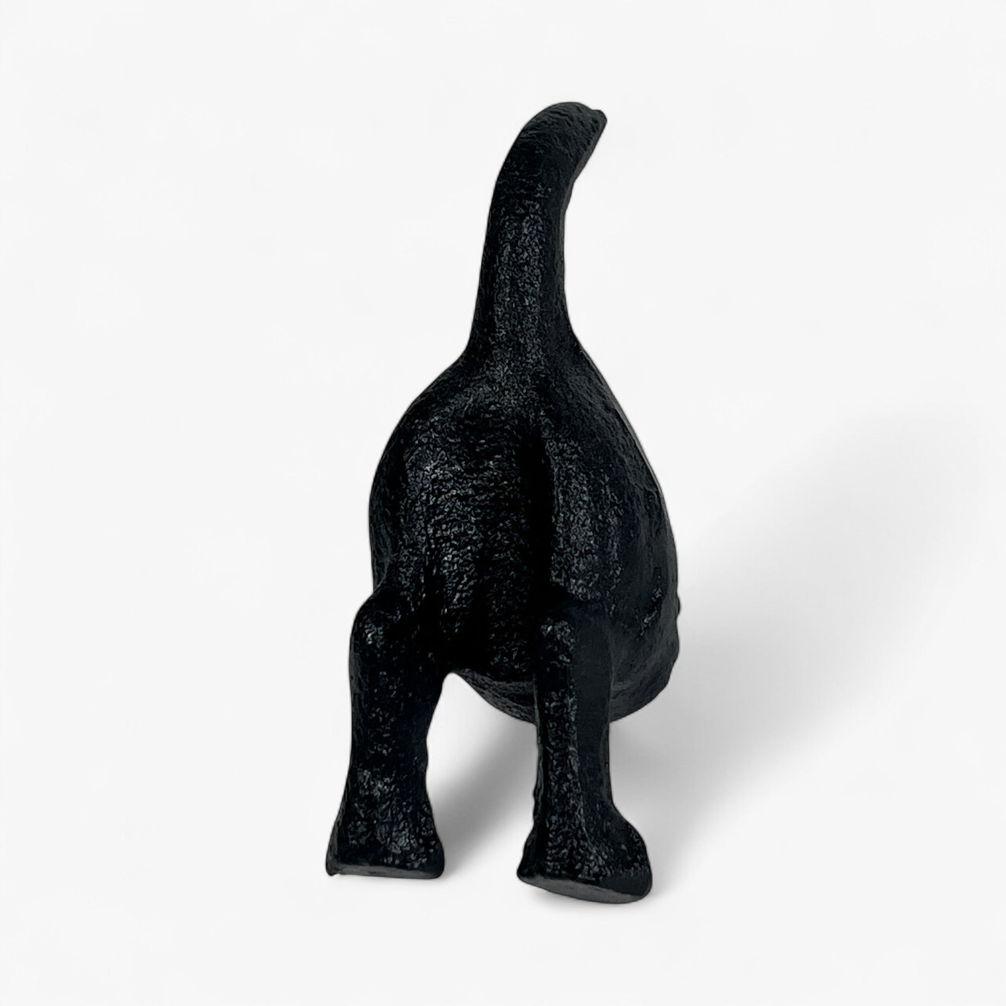 Cast iron dog statue with raised tail, textured black finish, standing view