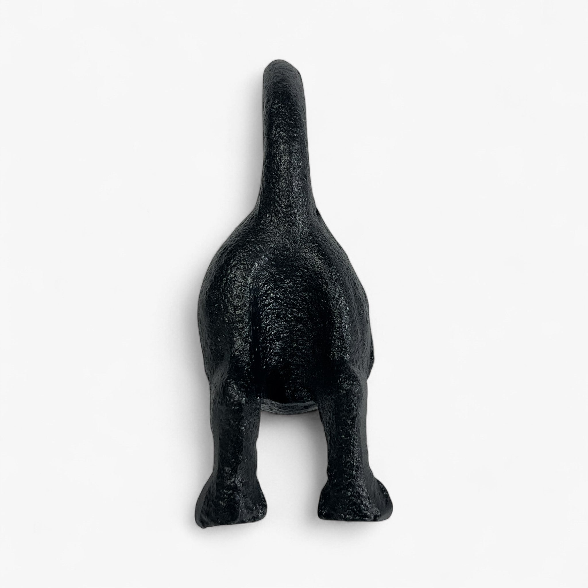Black cast iron dog figurine front view, detailed texture, upright tail accent
