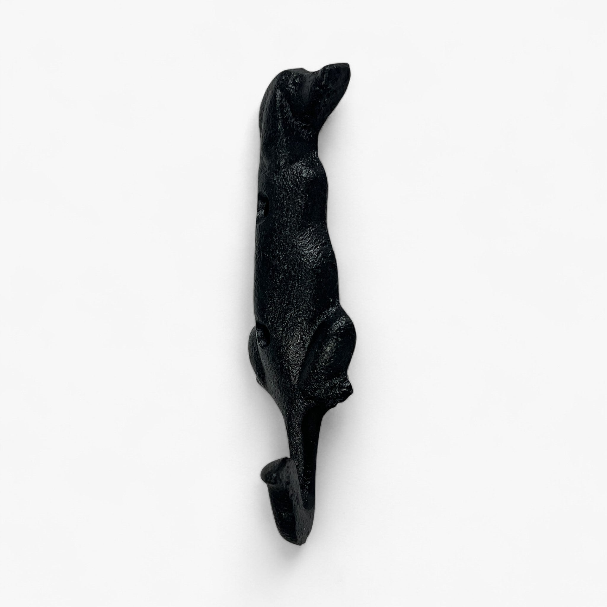 Cast iron dog hook in profile view showing full body length with tail, rough black finish