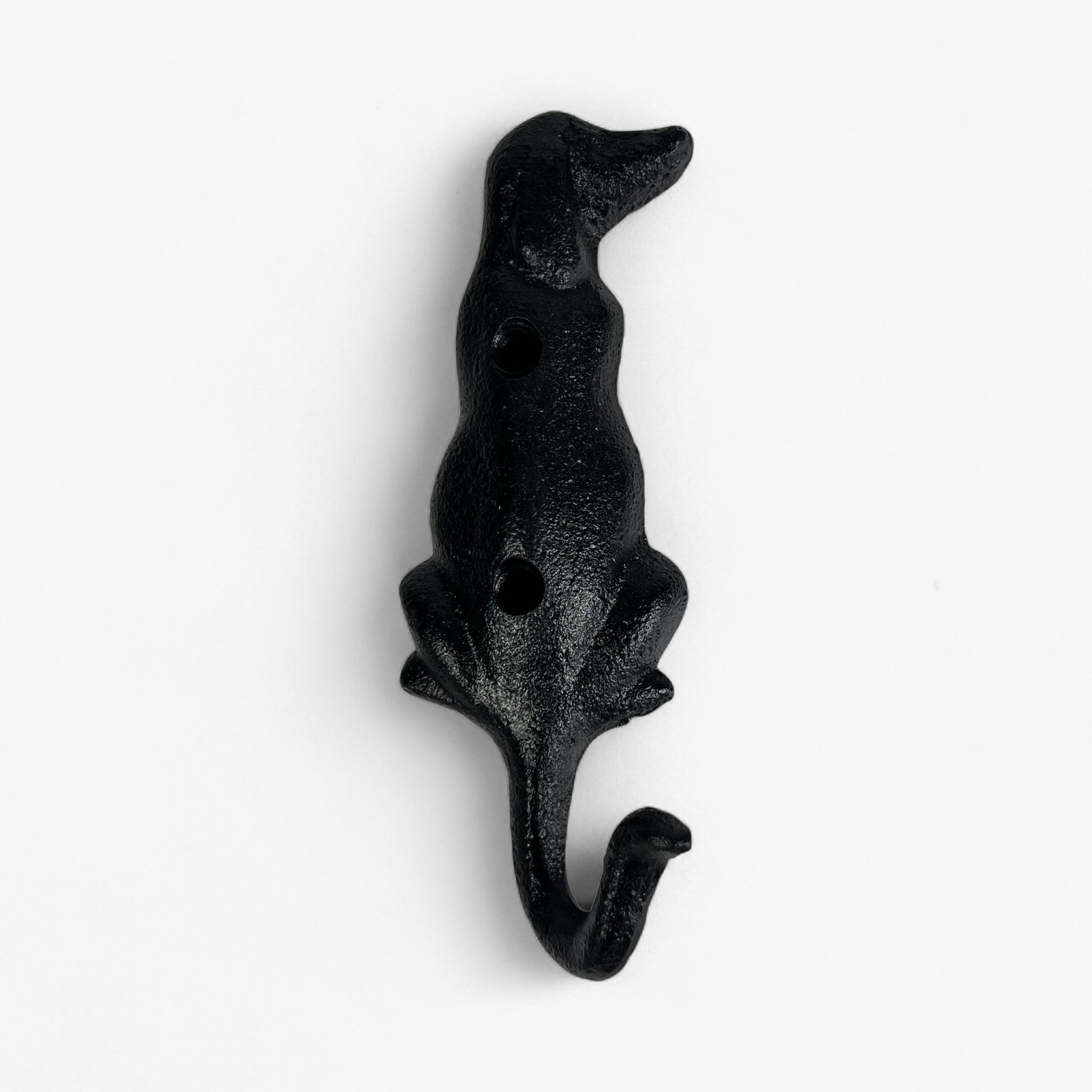 Black textured cast iron dog figure wall hook with upright ears sitting pose on white background