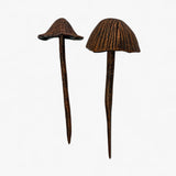 Pair of aged copper mushroom garden stakes with varied cap flare and antiqued finish details