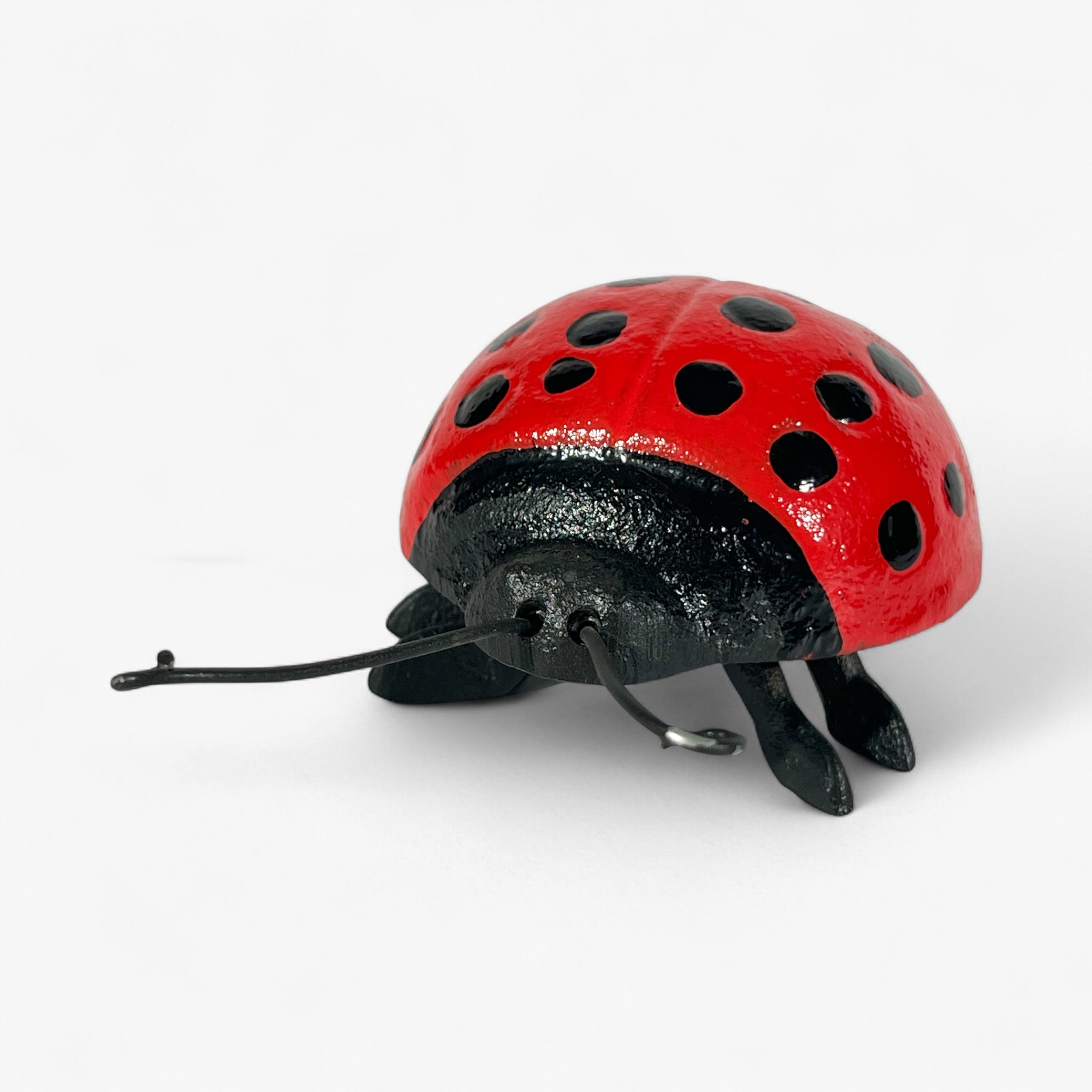 Cast iron ladybug decor showing curved shell and black leg details from above