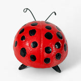 Red cast iron ladybug with extended antennae and six black legs, top view