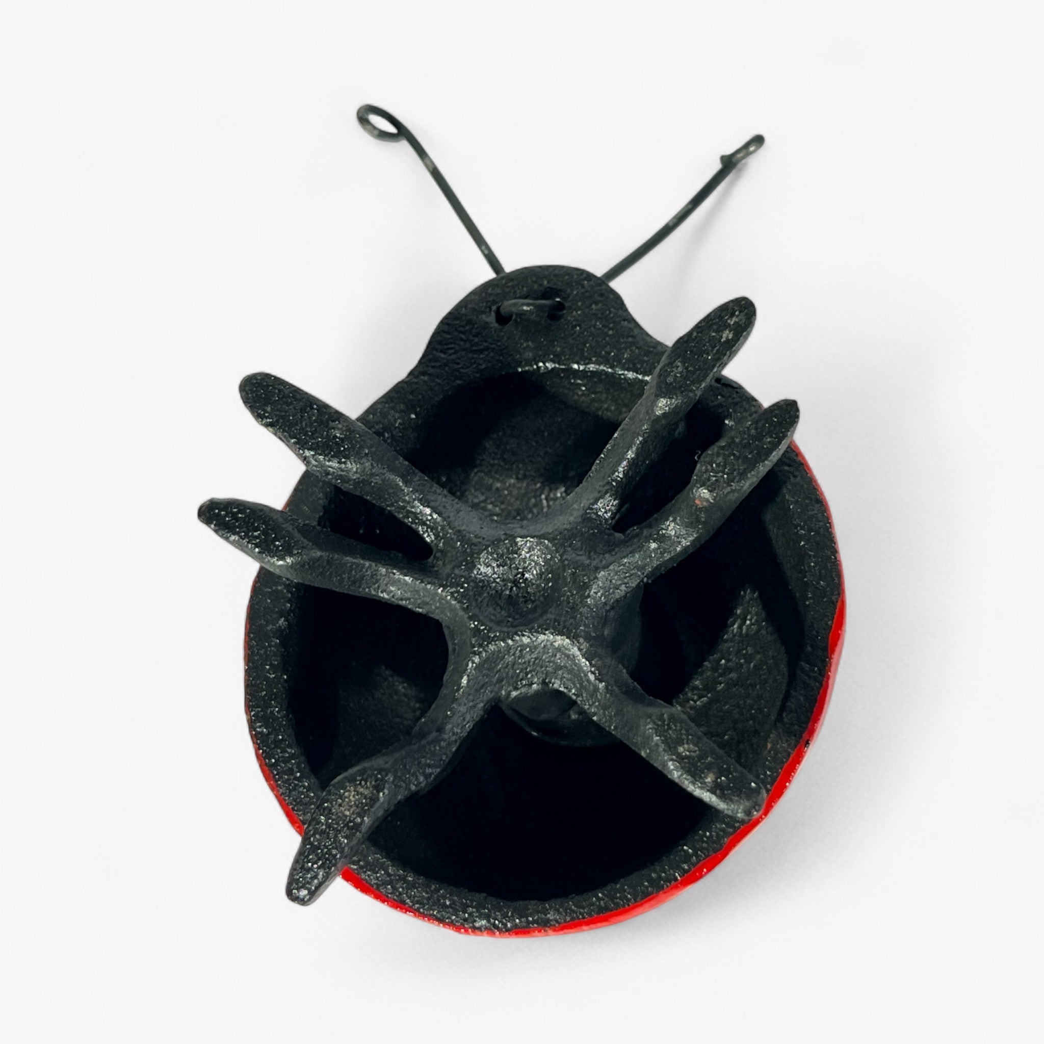 Cast iron ladybug bottom view revealing hollow black interior and metal construction