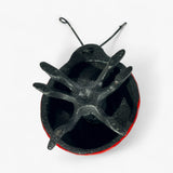 Cast iron ladybug bottom view revealing hollow black interior and metal construction