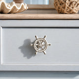 Distressed white ship wheel cabinet knob on a pale blue coastal dresser drawer