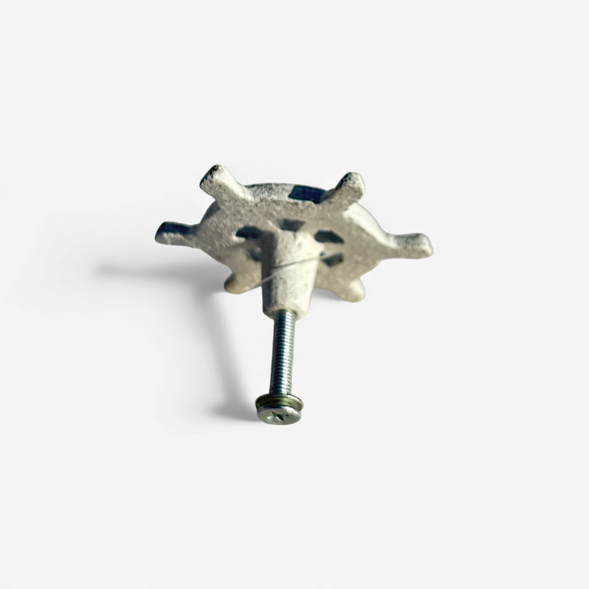 Antiqued brass ship wheel knob with mounting screw visible from side angle