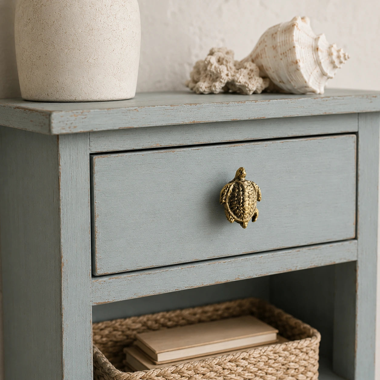 Brass sea turtle drawer knob on a distressed blue coastal nightstand drawer