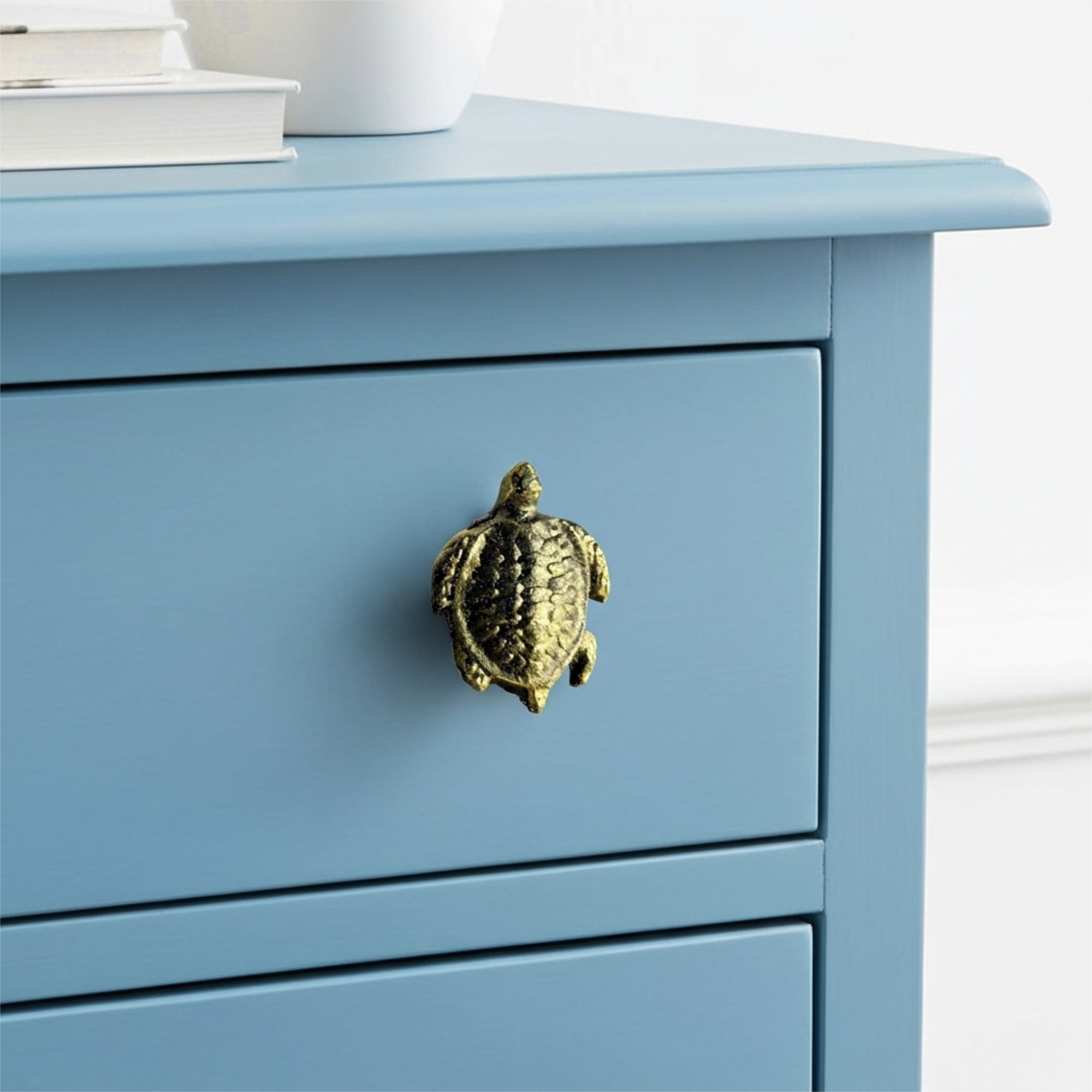 Distressed gold sea turtle drawer pull on blue cabinet, detailed coastal hardware knob