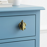 Distressed gold sea turtle drawer pull on blue cabinet, detailed coastal hardware knob