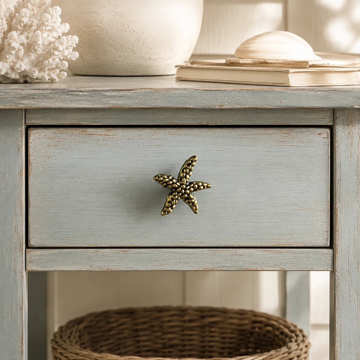 Brass starfish drawer knob centered on a distressed blue coastal nightstand drawer