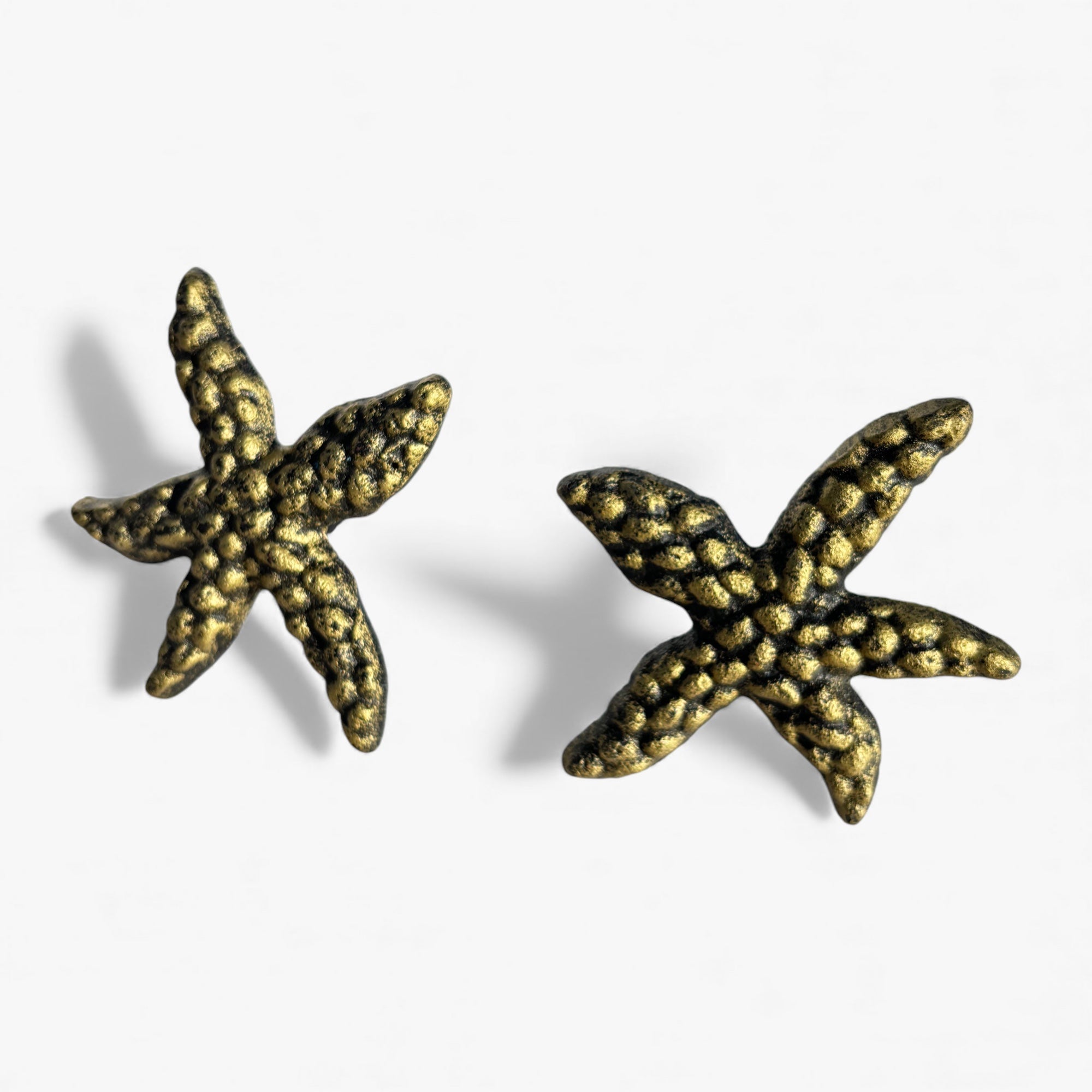 Two textured brass starfish drawer pulls, bumpy finish, side-by-side view
