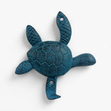 Three cast iron turtle hooks displayed: bronze, gold, and teal with shell detailing