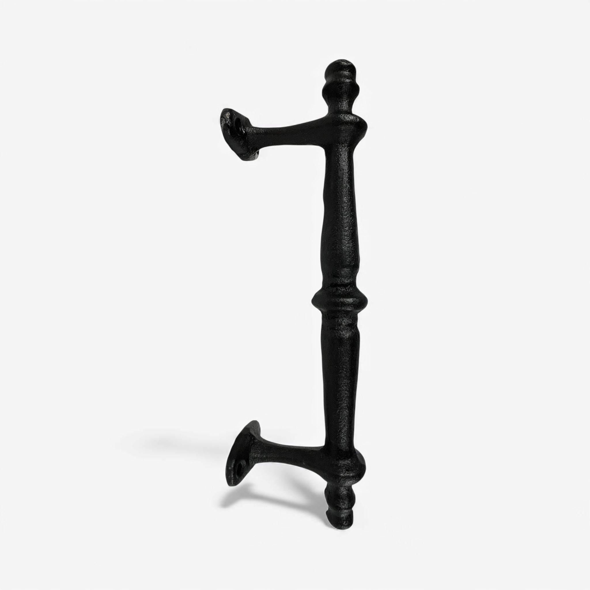 Cast iron door handle detail showing symmetrical design with decorative caps, glossy black