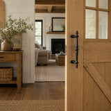 Wood barn door with black cast iron pull handle in a farmhouse entryway