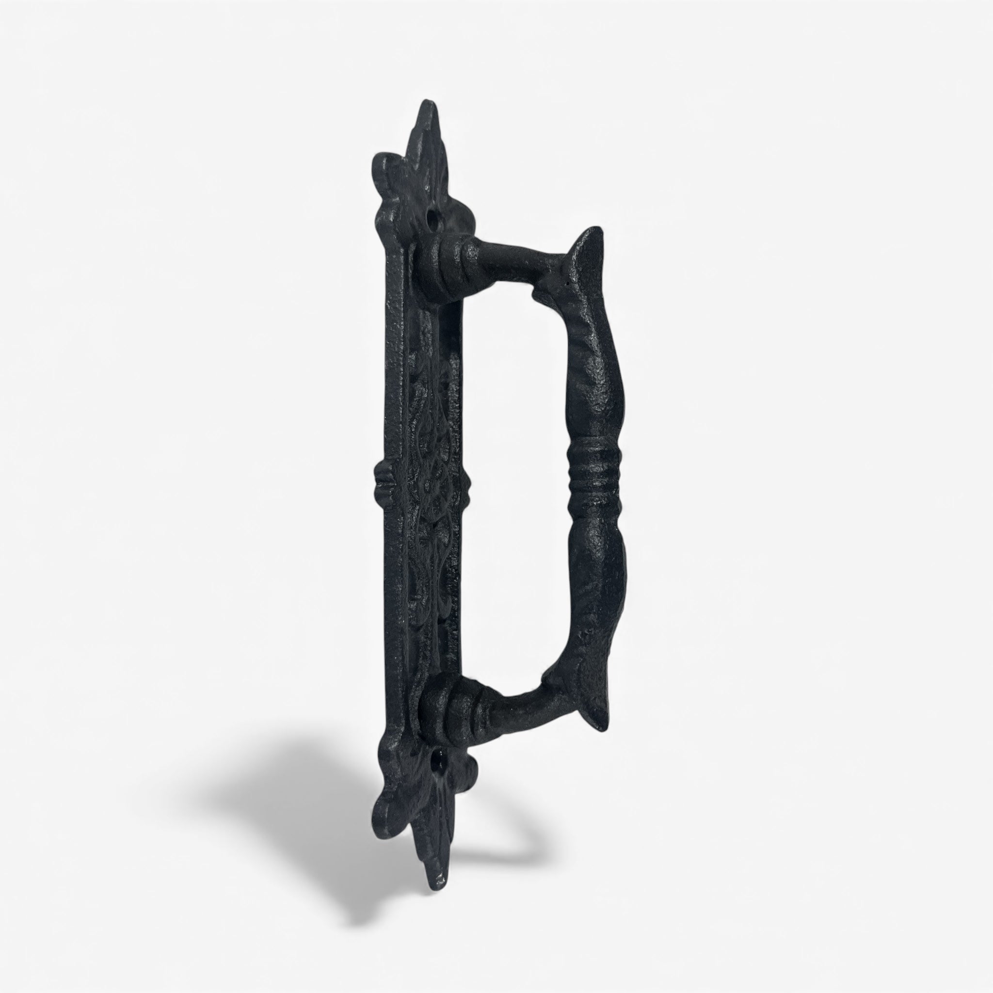 Black cast iron door pull hardware with decorative baroque details and curved grip