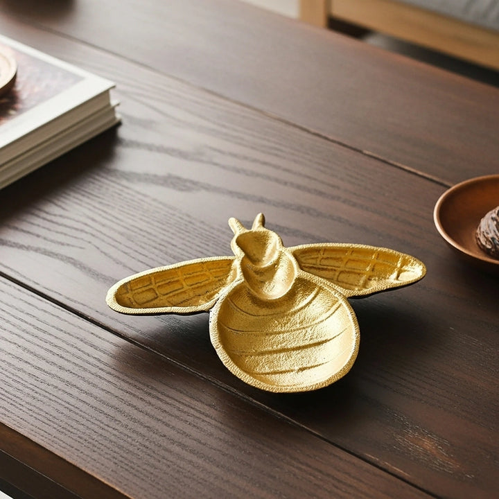 Gold cast iron bee trinket dish overhead view showing detailed molded body and wings