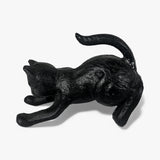 Cast iron black cat bookend laying down with tail curved upward, showcasing relaxed form from side