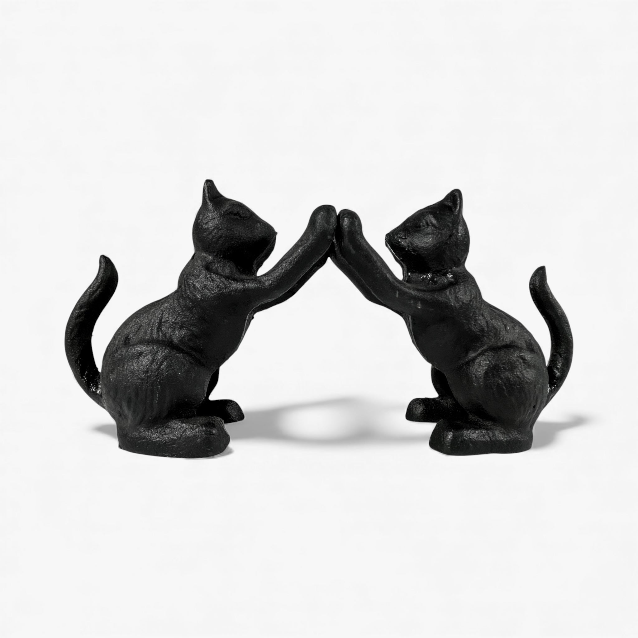 Pair of black cast iron cat bookends facing each other with paws raised, decorative home accent set
