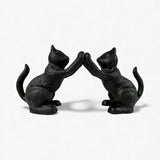 Pair of black cast iron cat bookends facing each other with paws raised, decorative home accent set