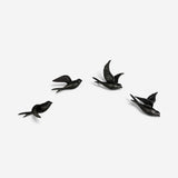 Four rustic black cast iron bird hooks arranged in grid wall-mounted home decor display