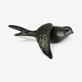 Cast iron bird wall hook in side view showing curved body and detailed wing texture