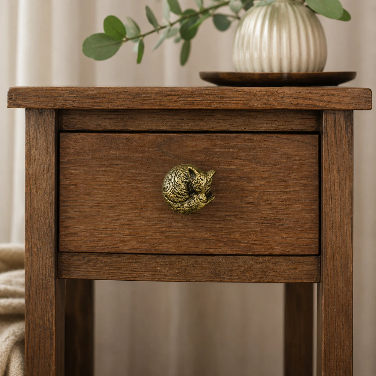 Wood nightstand with antique brass fox cabinet knob and vase decor