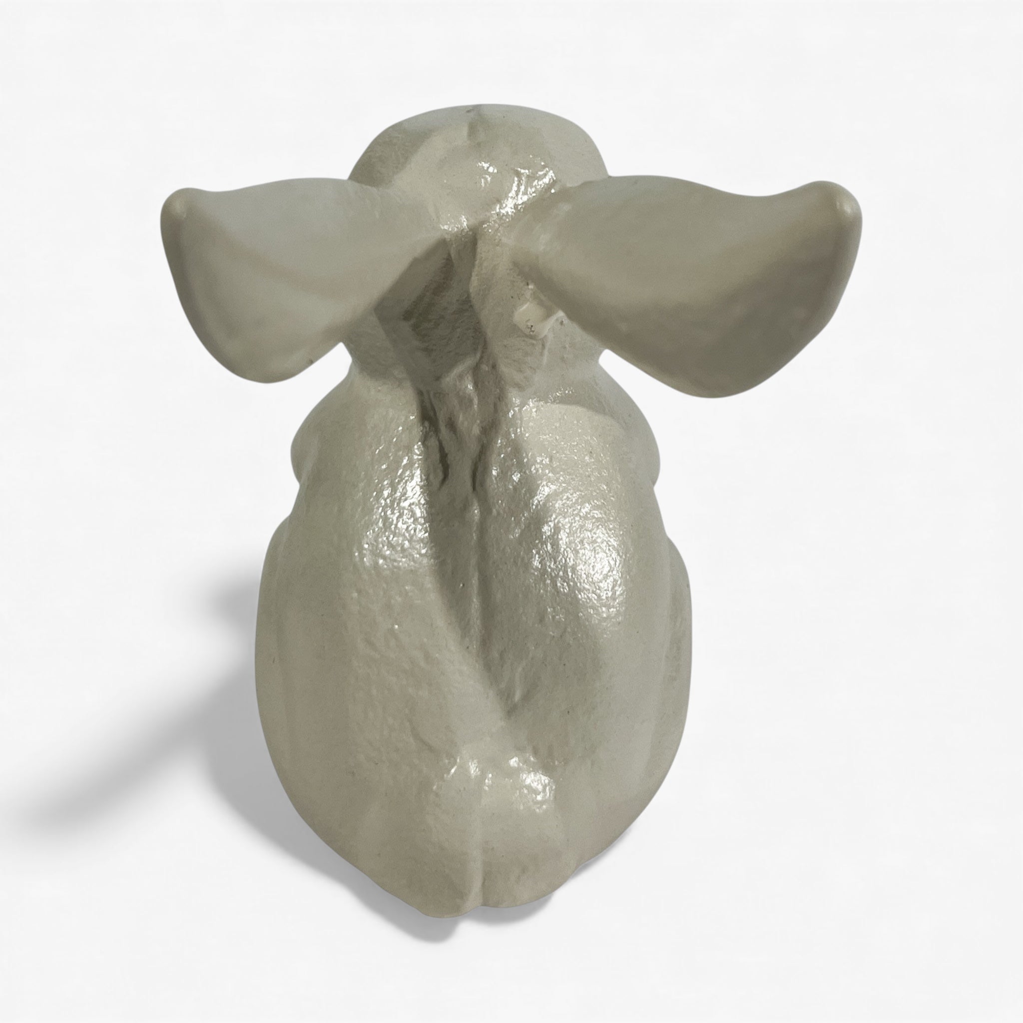 Cast iron bunny garden statue with shiny cream finish from back perspective with detailed sculptural work