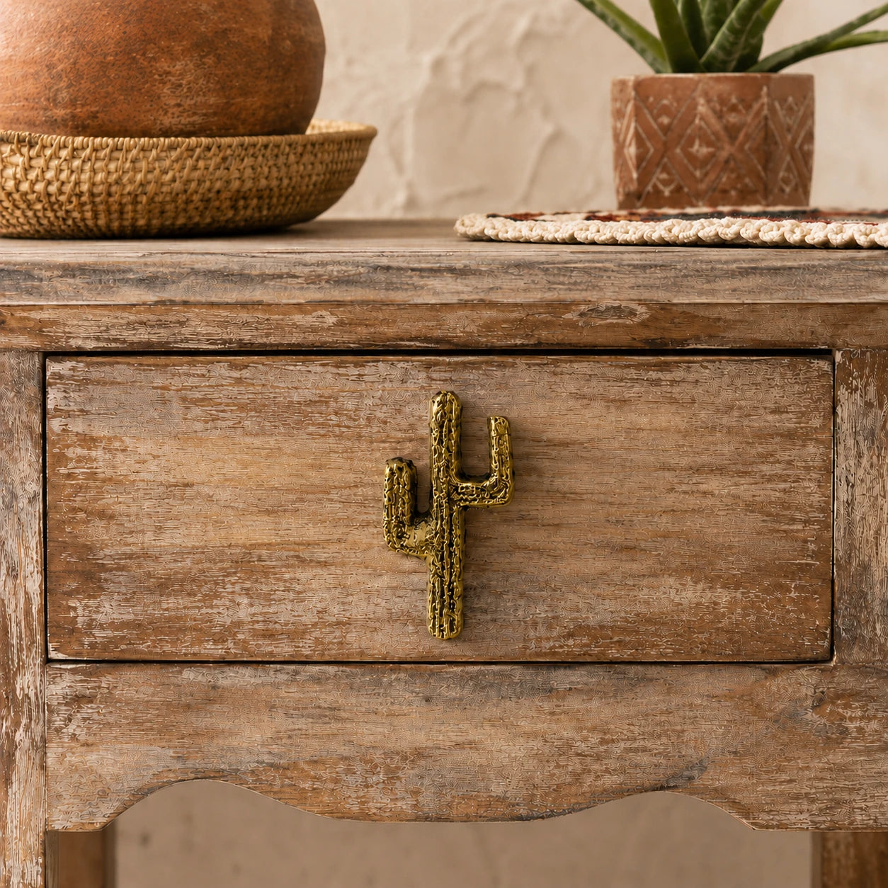 Close-up of cactus shaped drawer pull on a weathered wooden cabinet drawer
