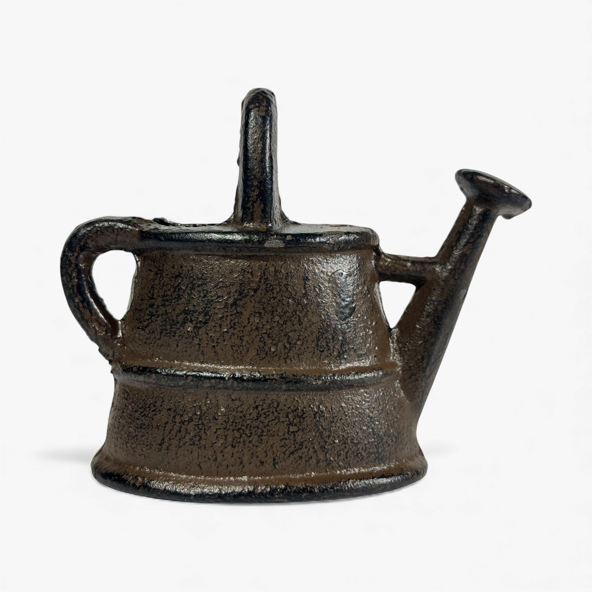 Dark cast iron watering can statue side view, weathered finish with cast iron spout and handle
