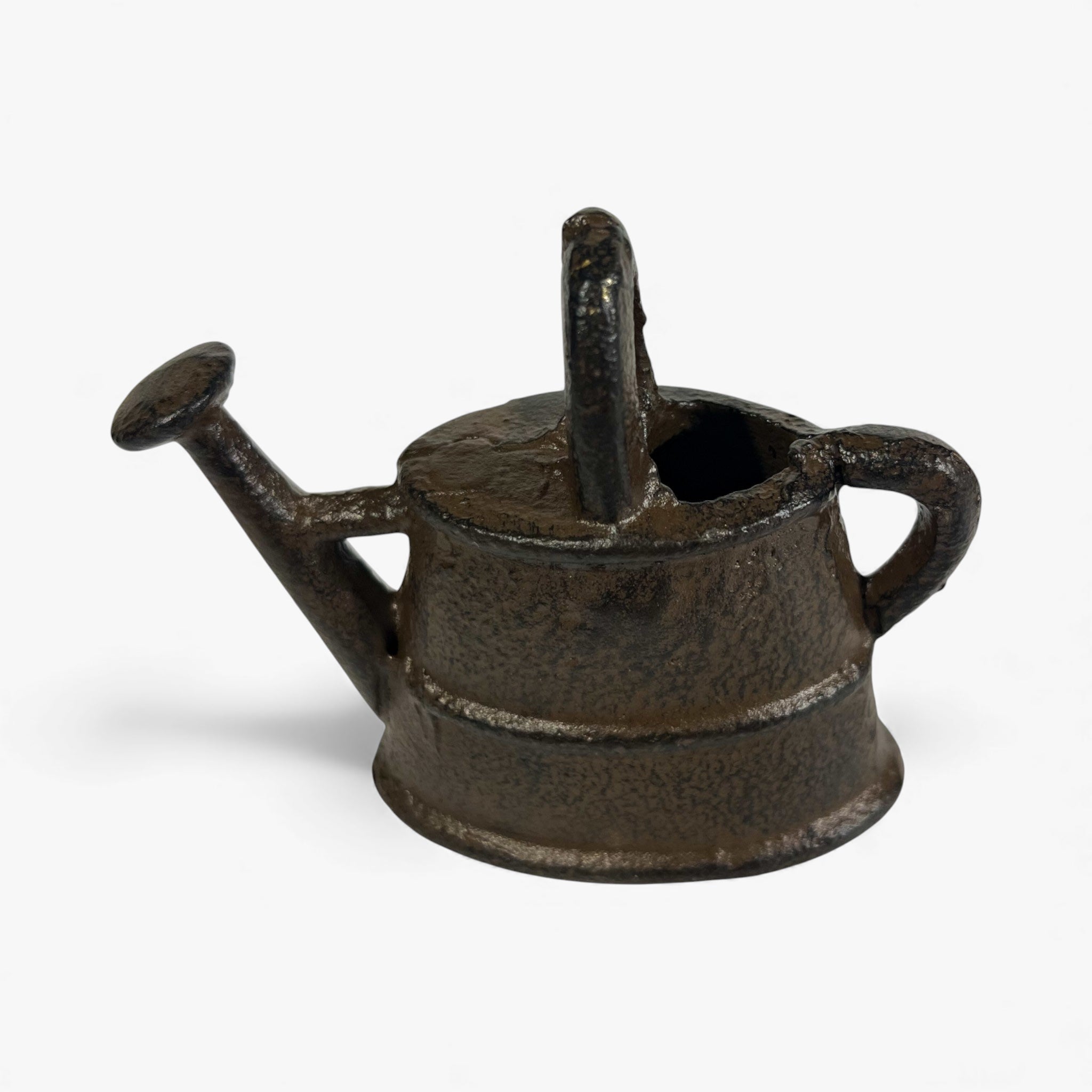 Top-down view of miniature cast iron watering can statue, showing spout and handle details