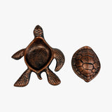 Top-down view copper cast iron turtle key hider with embossed shell details and rich patina