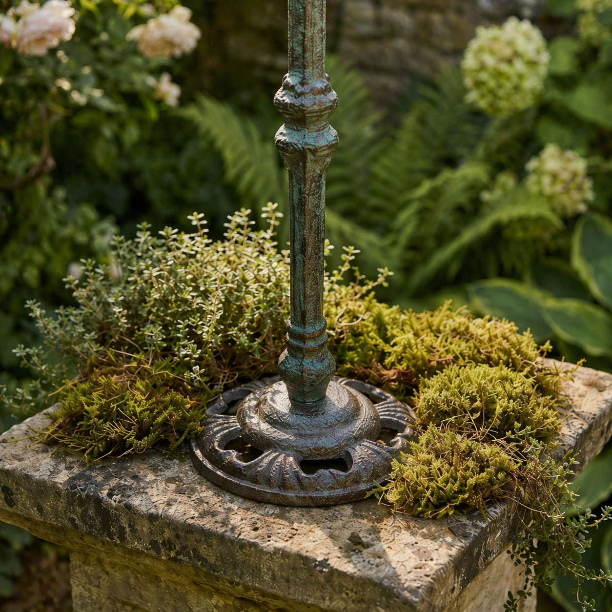 Cast iron bird feeder bowl detail on a garden pedestal.