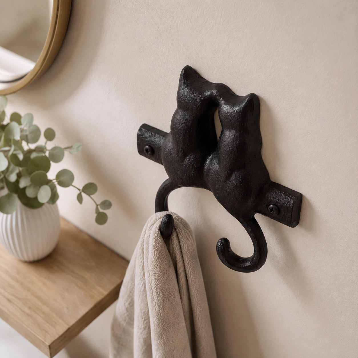 Angled view of black cast iron kissing cats wall hook with visible screws, SKU GB78064
