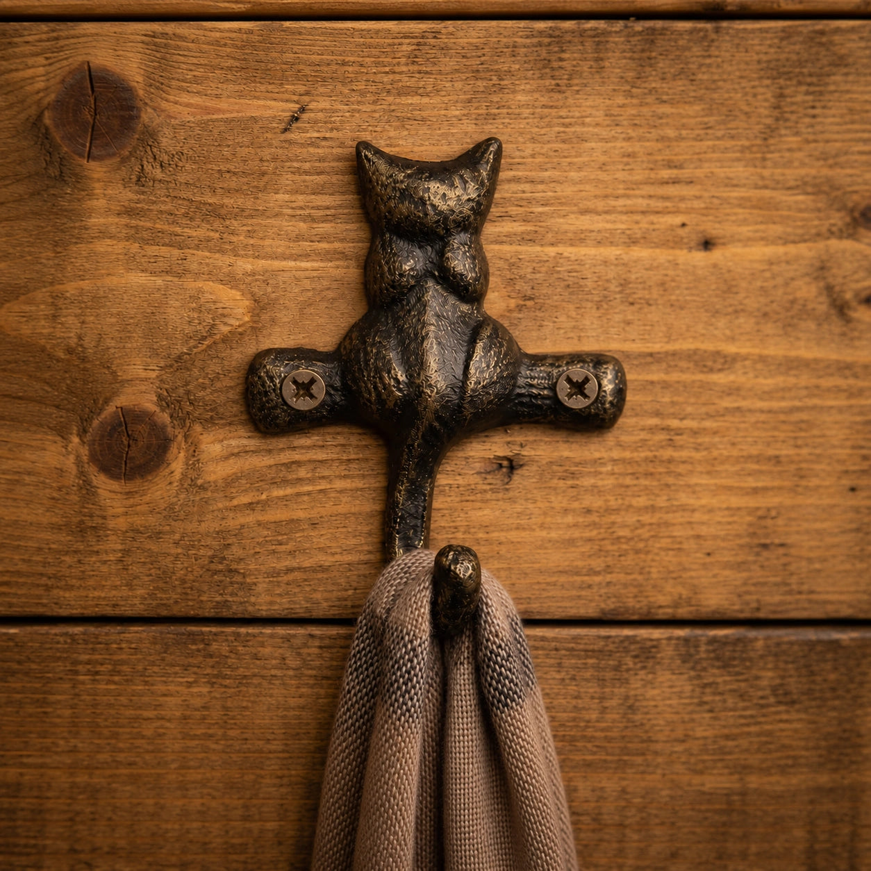 Close view of dark bronze cast iron cat hook holding a scarf, SKU GB78065