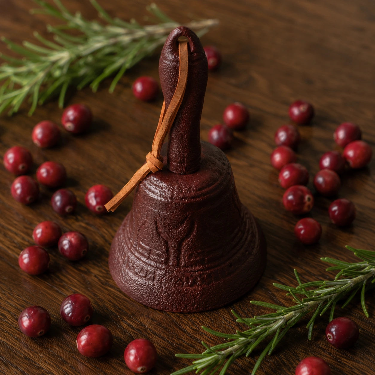 Burgundy cast iron dinner bell with leather strap, cranberries, and rosemary, SKU GB78097
