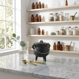 Lidded mini cast iron cauldron displayed on an apothecary-style shelf, SKU GB78125