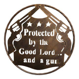 Circular metal wall art featuring dual revolvers, stars, and Protected by the Good Lord text