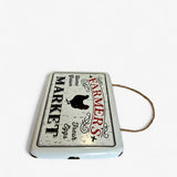 Overhead view of cream enamel Farmers Market sign with rope twine handle