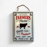 Distressed white metal farmers market sign with cow silhouette, rope hanging cord